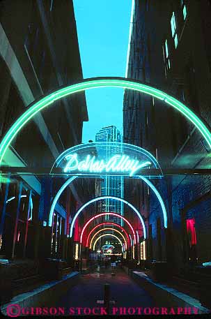Stock Photo #11824: keywords -  alley arch buildings curve curved dallas dark district downtown dusk end evening lighting lights neon night round texas vert west